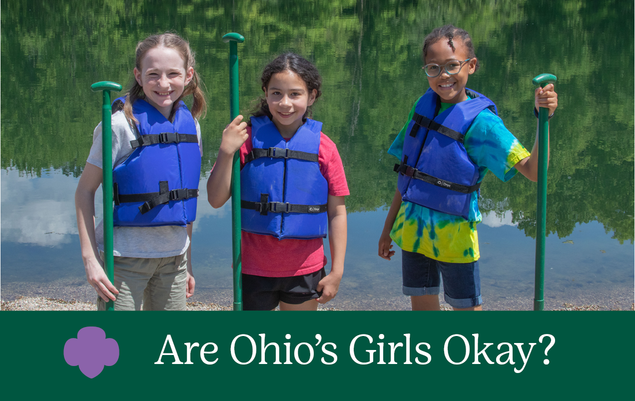 A group of girl scouts of western ohio staff standing in front of the toledo office
