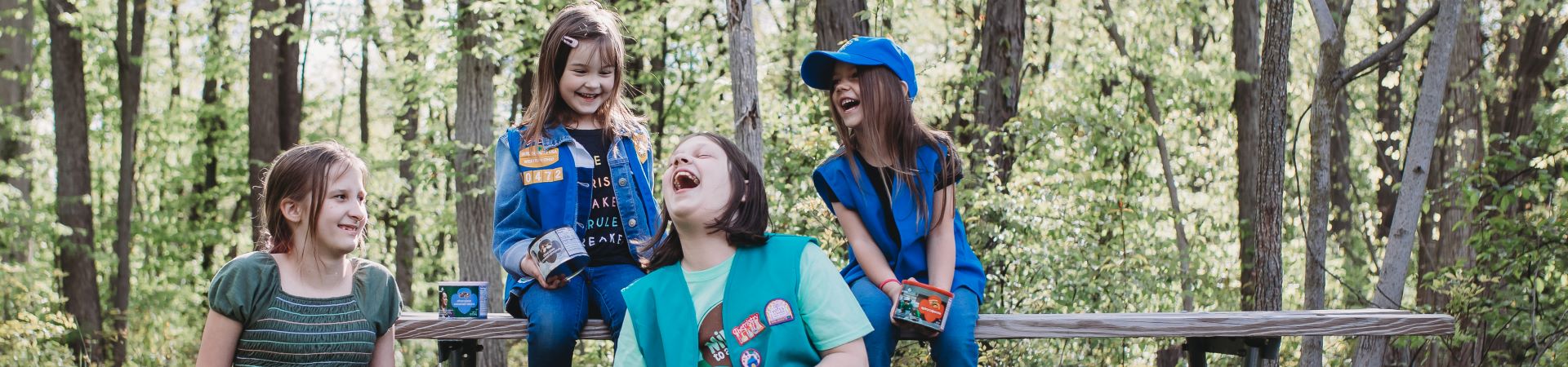  A group of girls laughing outdoors surrounded by nuts and candy products 