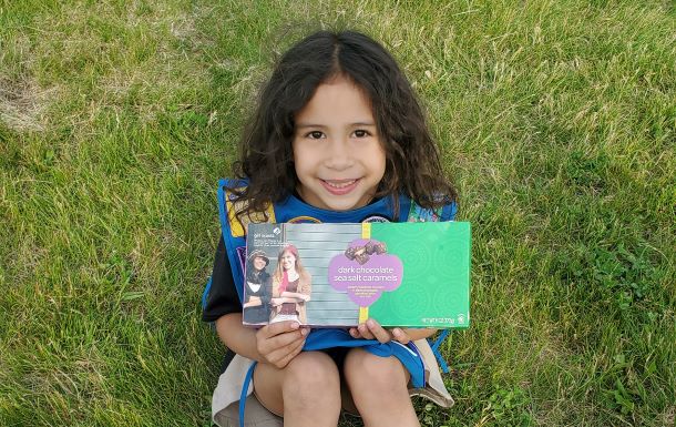 Daisy Girl Scout holding a box of candy