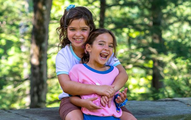 Two young girls gigling and wearing Girl Scout apparrel