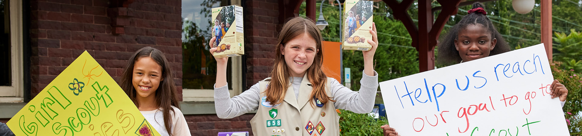  Three Girl Scouts working at a cookie booth 