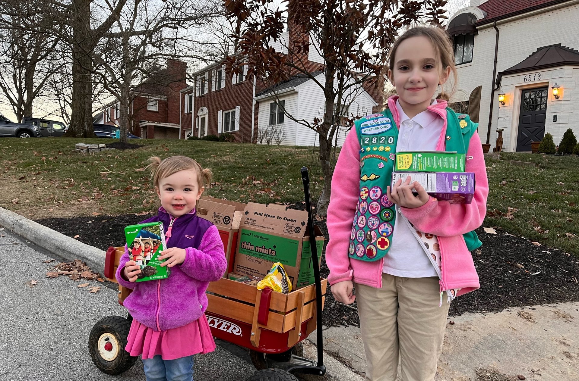 Two girls with cookies in a wagon