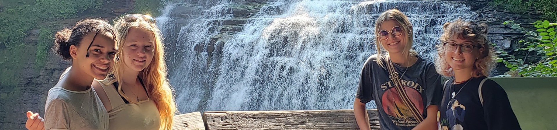  Four girls smiling in front of a waterfall 