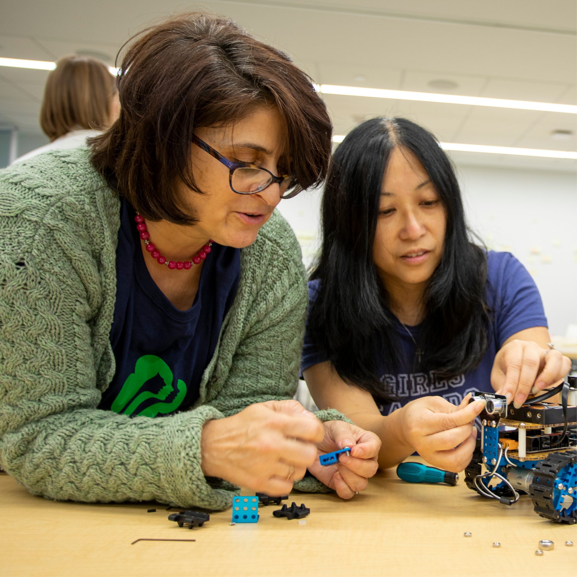 Volunteers working together to build a robot