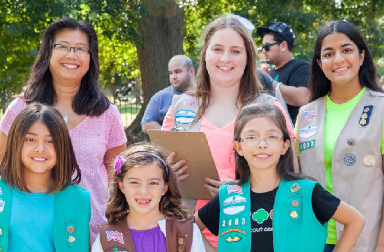 A group of girls and volunteers smiling while outdoors