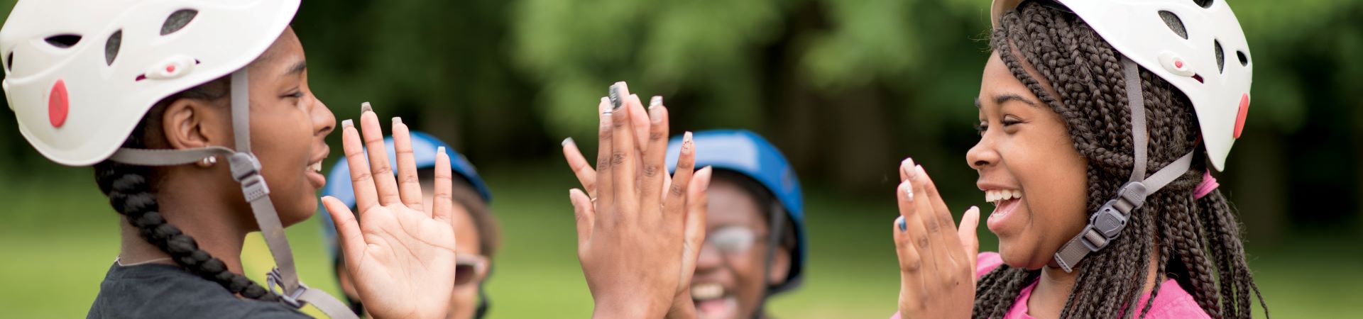  Two Girl Scouts playing pattycake while wearing climbing gear 