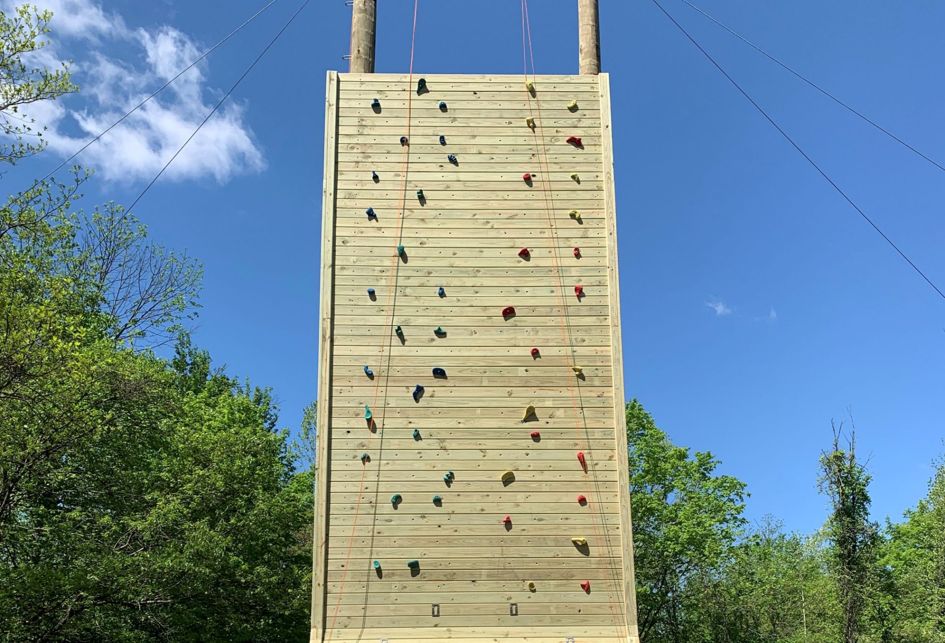 The new climbing wall at Camp Stonybrook with a blue sky and clouds behind it