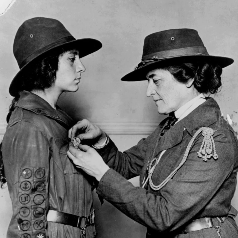 Girl Scout founder Juliette Gordon Low pinning a Girl Scout